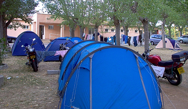 tents and bikes outside a toilet block on a very dry and arid campsite